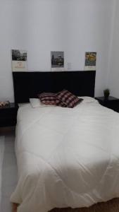 Una cama blanca con una almohada encima. en Kitnet Aconchegante em Vitória, B. República en Vitória
