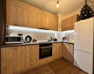 a kitchen with wooden cabinets and a white refrigerator at Petkovi Аpartments, Borovets Gardens - One-bedroom and Two-bedroom apartments in Borovets