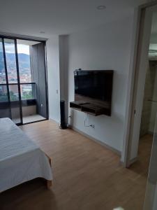 a bedroom with a flat screen tv on a wall at Super Loft Sabaneta, Class48 Cerca a todo in Sabaneta