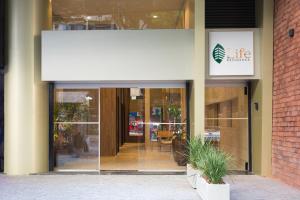 an entrance to a building with a large glass door at Life Residence in Belo Horizonte