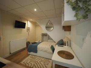 Habitación pequeña con cama y mesa en 8 appartements - studio - F2 - WIFI gratuit, en Gien