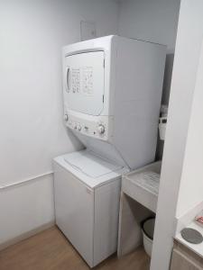 a kitchen with a microwave and a washer and dryer at Super Loft Sabaneta, Class48 Cerca a todo in Sabaneta