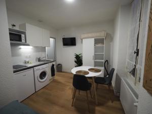 una pequeña cocina con mesa y sillas en una habitación en 8 appartements - studio - F2 - WIFI gratuit, en Gien