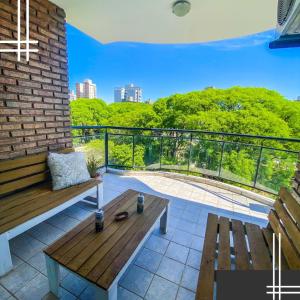 a patio with a wooden bench and a balcony at Departamento Good Vibes 2 in Paraná