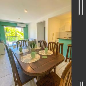 a dining room and kitchen with a wooden table and chairs at Departamento Good Vibes 2 in Paraná