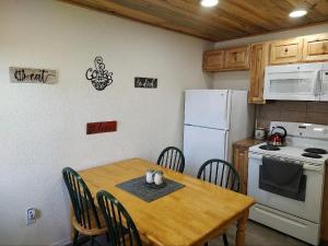 a kitchen with a wooden table and a white refrigerator at Gilmore Cabin in Miramonte