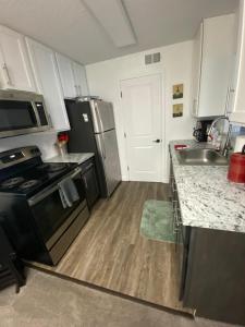 a kitchen with a stainless steel refrigerator and a sink at Miami U Gallery Superior King Private Bedroom in Shared Apartment in Oxford
