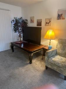 a living room with a table and a chair and a television at Miami U Gallery Superior King Private Bedroom in Shared Apartment in Oxford