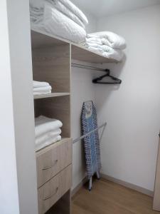 a closet with white towels and a surfboard at Super Loft Sabaneta, Class48 Cerca a todo in Sabaneta