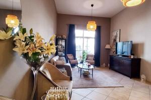 a living room with a vase of flowers on the wall at One Bedroom Apartment (Peaceful & Cozy) in Dubai