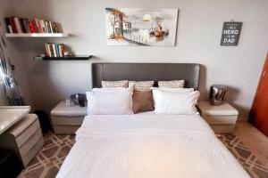 a bedroom with a bed with white sheets and pillows at One Bedroom Apartment (Peaceful & Cozy) in Dubai