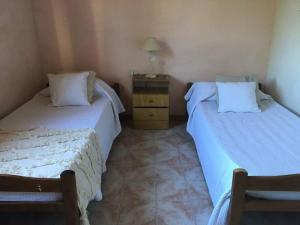1 dormitorio con 2 camas y vestidor con lámpara en Casa de vacaciones a minutos de la playa y el centro en Mar del Plata