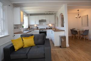 a living room with a couch and a kitchen at Apartment in the heart of Old Town Beaconsfield in Buckinghamshire