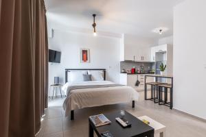a bedroom with a bed and a small kitchen at Pagani Green - Luxury Studio A2 in Kalamata
