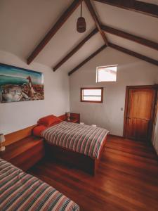 a bedroom with two beds and a painting on the wall at Ecolodge Santo Campo in Isla de Sol