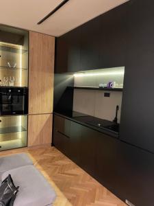 uma cozinha com armários pretos e um forno de aço inoxidável em Gray Apartments em Strumica