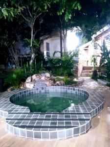 une petite piscine au milieu d'un jardin dans l'établissement Pousada Recanto Guatambu - Sobrado, à Chapada dos Guimarães