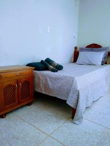 - une chambre avec un lit et une armoire en bois dans l'établissement Pousada Recanto Guatambu - Sobrado, à Chapada dos Guimarães
