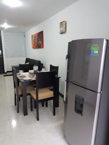 eine Küche und ein Esszimmer mit einem Tisch und einem Kühlschrank in der Unterkunft Lindos Apartamentos para Vacaciones in Montenegro