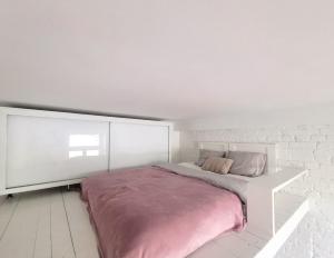 a white bedroom with a large bed with pink sheets at Warsaw Concierge Radna in Warsaw