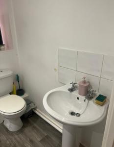 a white bathroom with a toilet and a sink at Casa Amor Homes in Shrewsbury