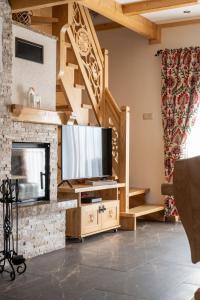 Il comprend un salon avec une cheminée et une télévision. dans l'établissement Lux-HOUSE & JACUZZI SAUNA, à Zakopane
