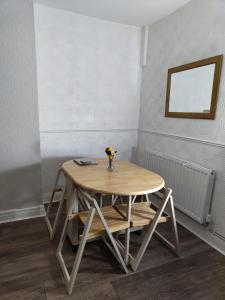 Anstuns LODGE في ليفربول: طاولة خشبية عليها مزهرية في الغرفة