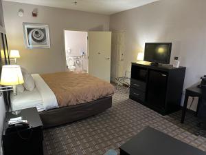 um quarto de hotel com uma cama e uma televisão de ecrã plano em Quality Inn Ashland em Ashland