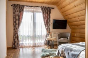 sypialnia z łóżkiem i dużym oknem w obiekcie Lux-HOUSE & JACUZZI SAUNA w Zakopanem