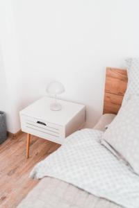 um quarto com uma cama e uma mesa de cabeceira branca em Apartmány Železničářská em Ústí nad Labem