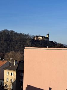 a castle on top of a hill behind a building at Apartmány Železničářská in Ústí nad Labem