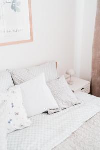 Una cama con sábanas blancas y almohadas. en Apartmány Železničářská en Ústí nad Labem