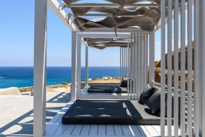 een veranda met uitzicht op de oceaan bij Mykonos Residence Villas & Suites Merchia Beach in Merchia Beach