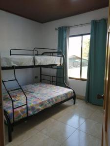 een slaapkamer met 2 stapelbedden en een raam bij Mirada al Cerro, Apartamento completo in Grecia