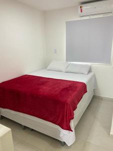 聖何塞皇冠大的住宿－Flats Sol e Mar，卧室配有一张带红色毯子的白色床