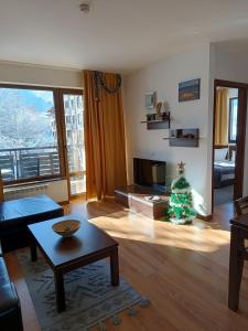 a living room with a christmas tree on the floor at M&R Apartment C13 - SPA Terra Complex in Razlog