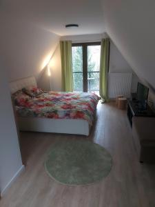 a bedroom with a bed and a large window at Vikendica Tuzla, Dolina mira in Tuzla