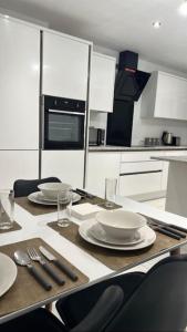 a kitchen with a table with plates and utensils at Brand New 3 bedroom House in Gated Development! in Polesworth