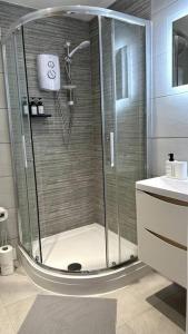 a shower with a glass door in a bathroom at Brand New 3 bedroom House in Gated Development! in Polesworth