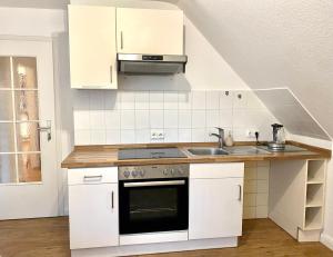 a white kitchen with a sink and a stove at My Loft by Essen 2 Apartments in Rosengarten