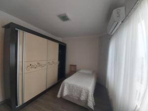 Habitación pequeña con cama y armario grande. en Apartamento Margarida, en Foz do Iguaçu