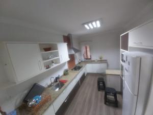 cocina con fregadero y nevera blanca en Apartamento Margarida en Foz de Iguazú