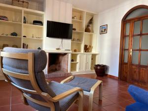 - un salon avec une chaise et une cheminée dans l'établissement Pátio do Alqueva - Alojamento Local, à Granja