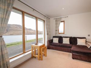 a living room with a couch and large windows at Tigh na Creag in Sconser