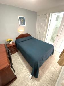 a bedroom with a bed with a blue comforter at Hotel Qualitel Plus in Morelia