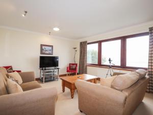 a living room with two couches and a tv at MacKenzies Peak in Sconser