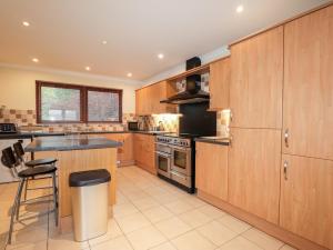 a kitchen with wooden cabinets and a stove top oven at MacKenzies Peak in Sconser