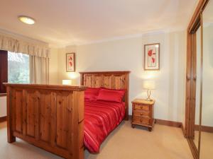 una camera da letto con un grande letto in legno con lenzuola rosse di MacKenzies Peak a Sconser