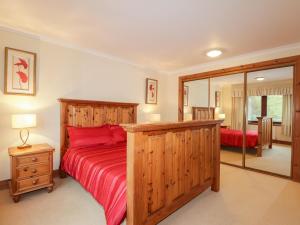 1 dormitorio con cama roja y espejo en MacKenzies Peak en Sconser