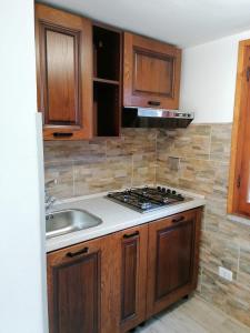 una cucina con lavandino e piano cottura forno superiore di Appartamento Scirocco a Marina di Campo